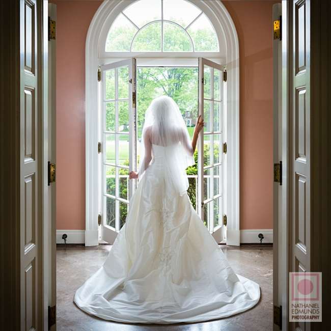 Bride poses by French glass doors