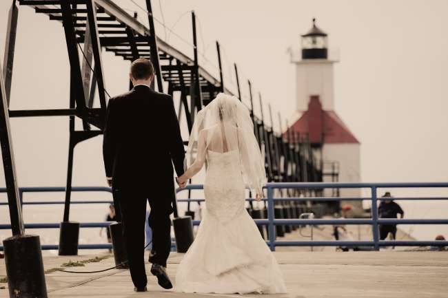 Bride & Groom Walking Down a Pier Towards a Lighthouse