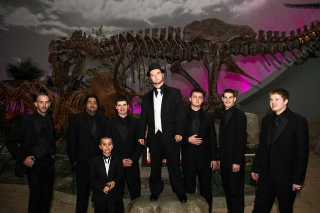 Groomsmen posing with dinosaur