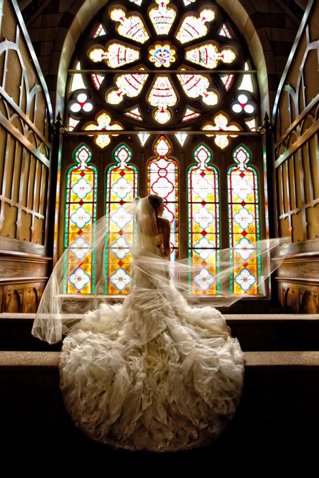 Breathtaking Shot of Bride in Front of Stained Glass Windows