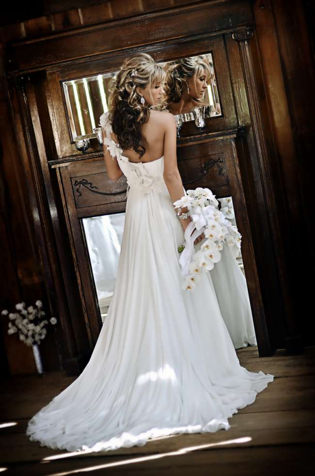 Bride Looking Over Her Shoulder With Orchid Bouquet